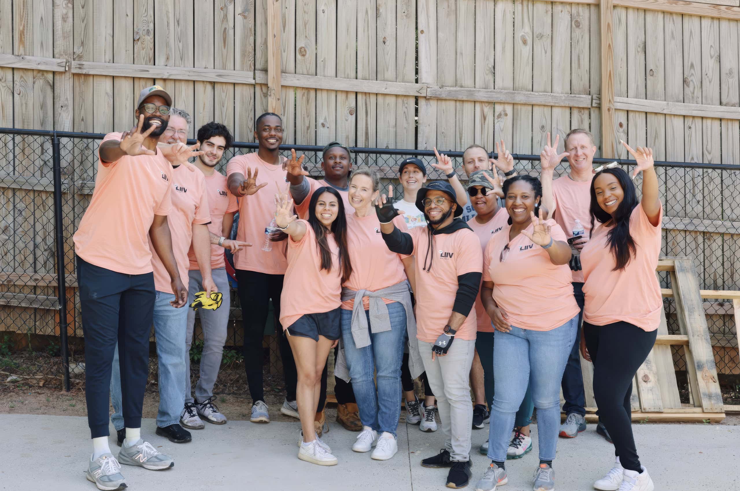 LIIV volunteers standing together in peach shirts